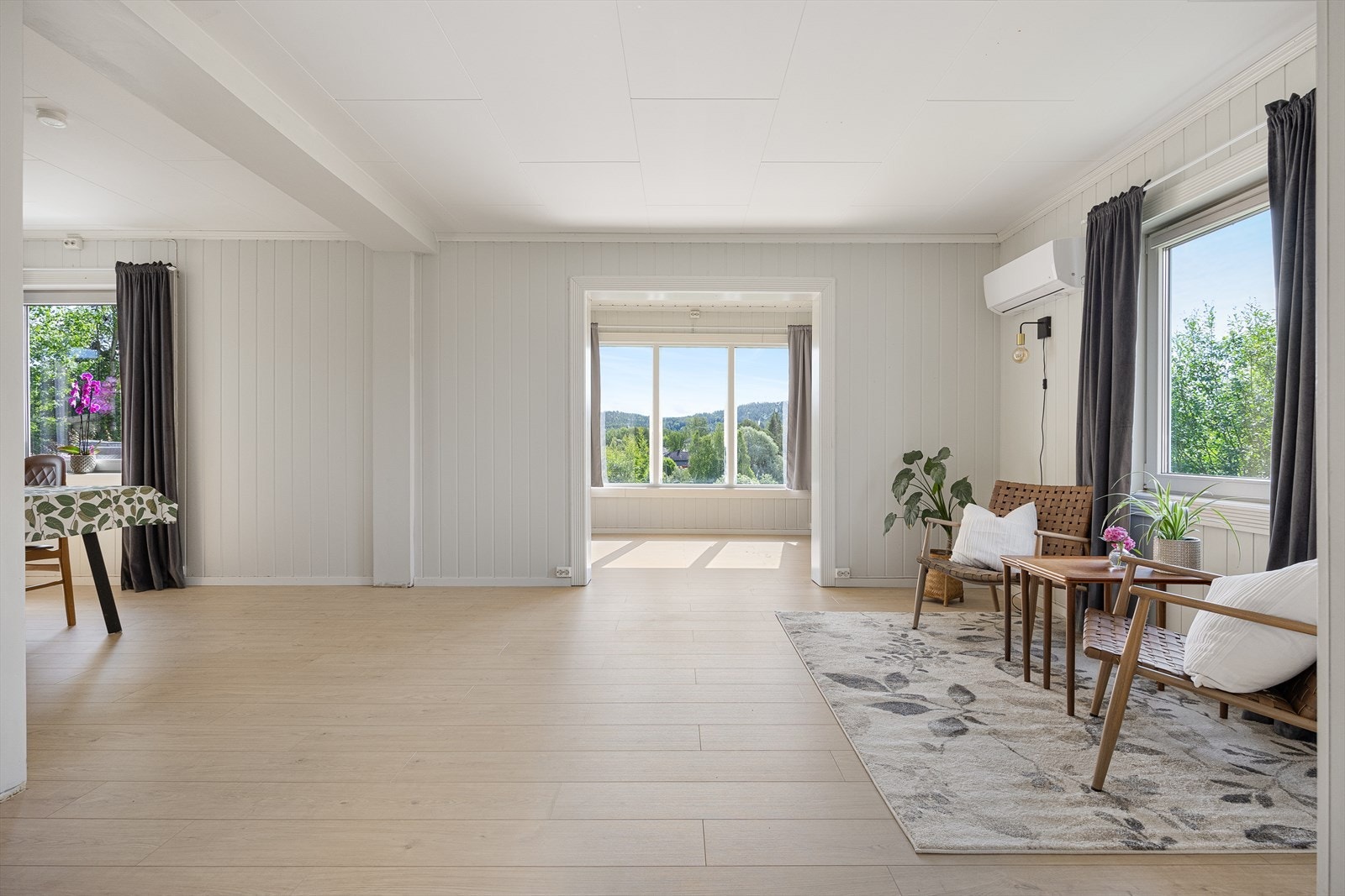 Det er tre innbydende stuer i eneboligens første etasje, og alle ligger i dels åpen løsning langs hele husets sydside. Galleribilde
