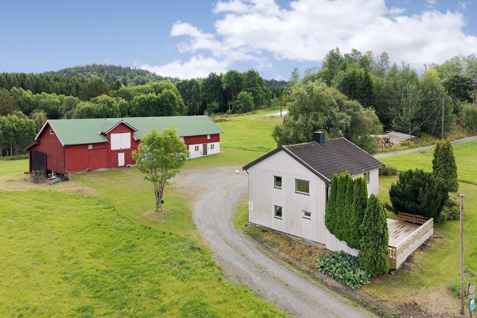 Eiendommen sett fra siden, med terrassen vendt mot jordene. Galleribilde