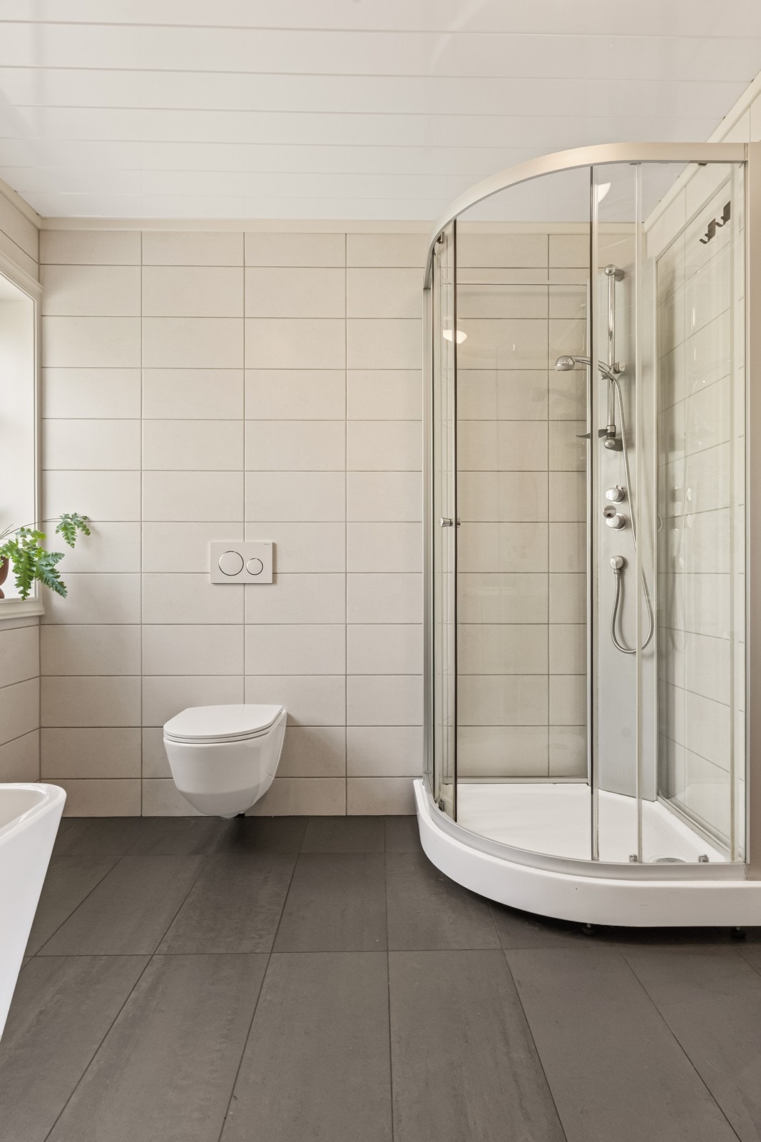 Badet er innredet med servant, toalett, dusjkabinett og badekar. Galleribilde