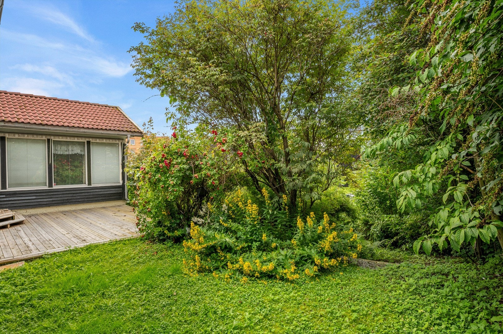 Terrassen ligger fint integrert mot hagen og har direkte adkomst fra boligens stue. Et naturlig samlingspunkt på fine sommerdager, med gode solforhold gjennom store deler av dagen. Galleribilde
