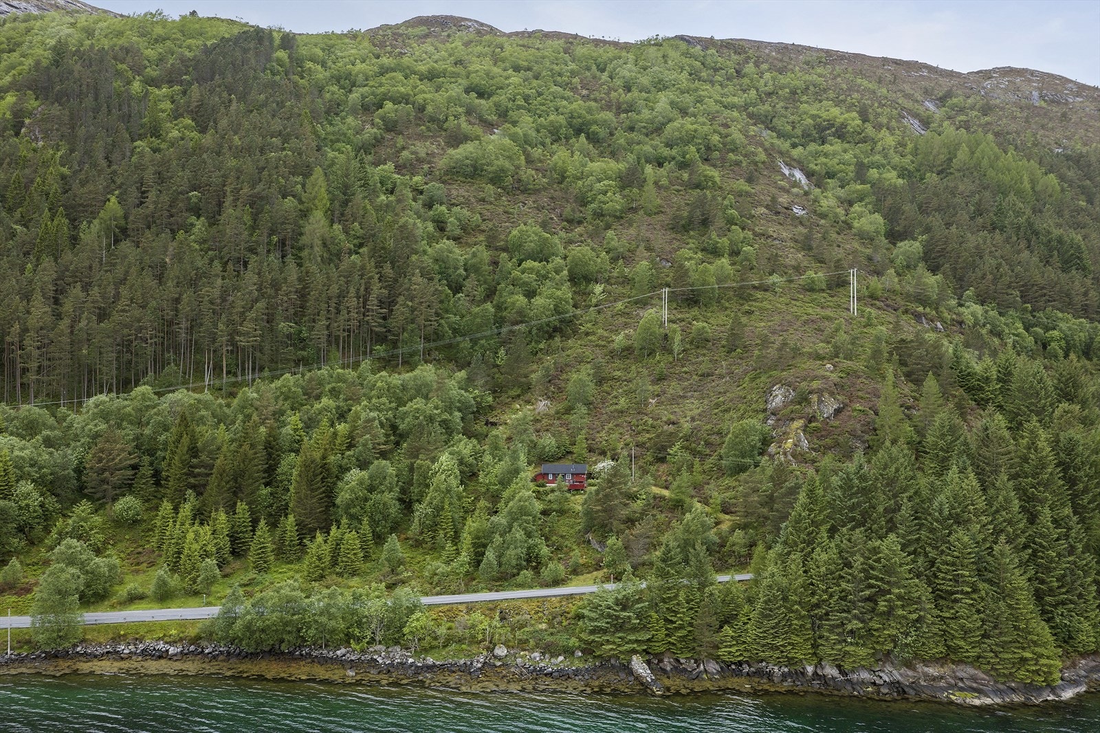 Fritidsbustaden ligg usjenert til i eit austvendt, skogkledd terreng. Galleribilde