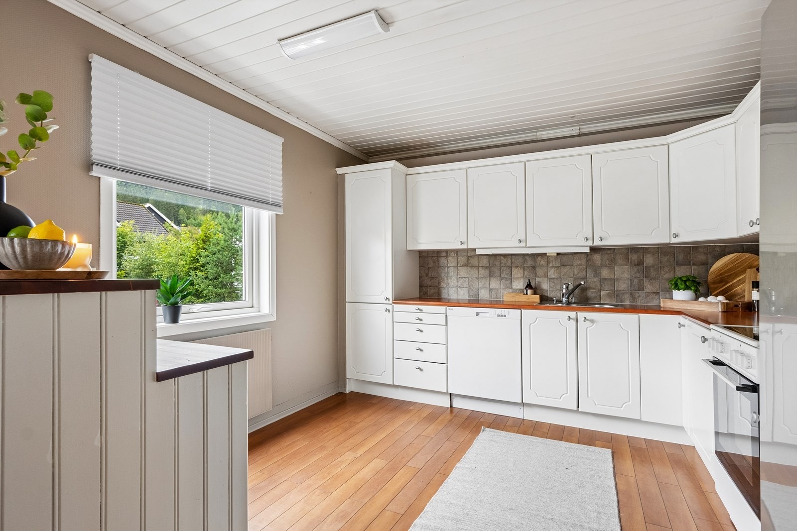 Kjøkkeninnredning med profilerte fronter og benkeplate av laminat. Galleribilde