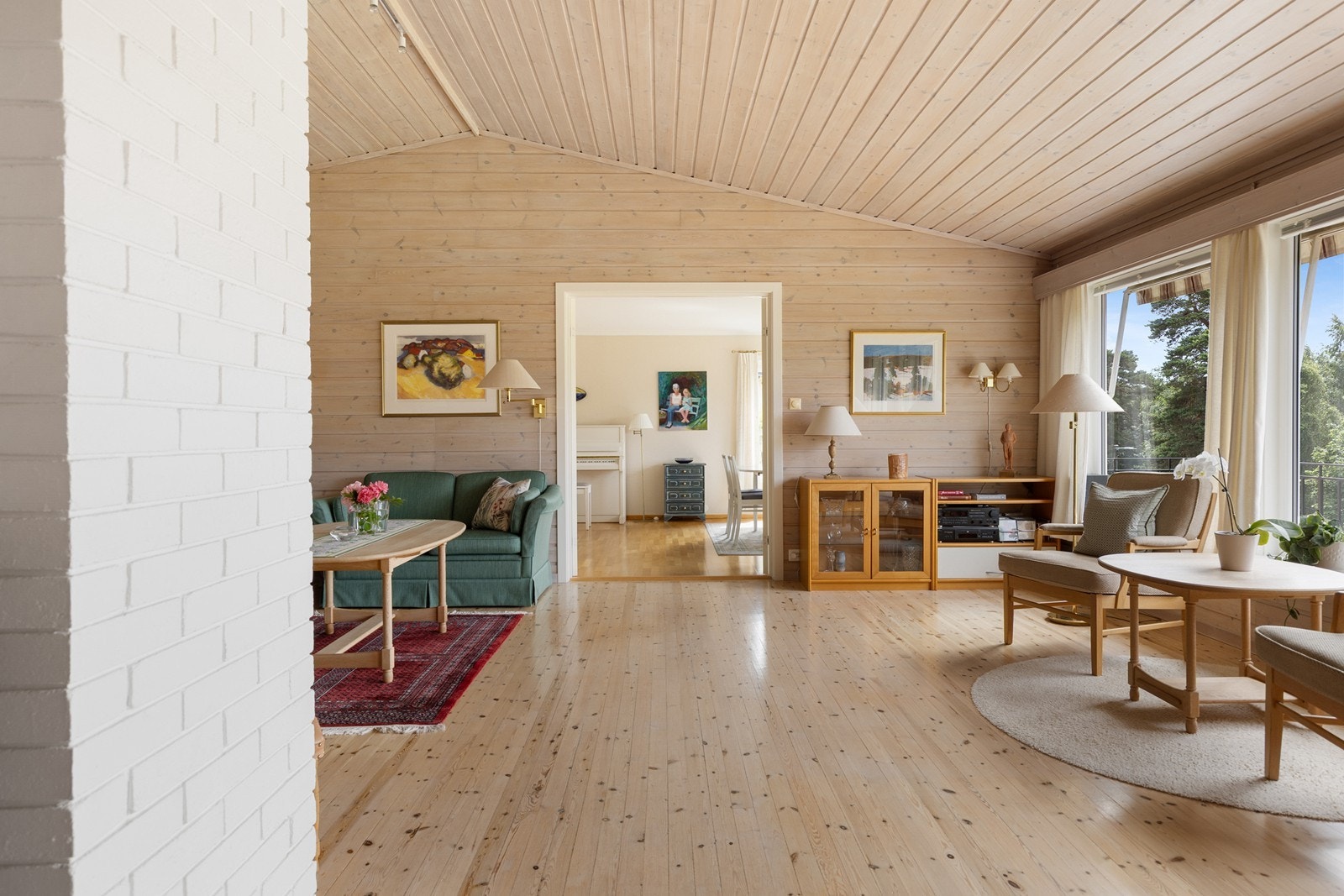 Oppholdsrommet byr på flott romfølelse, generøs takhøyde og utsyn mot grønne omgivelser. Galleribilde