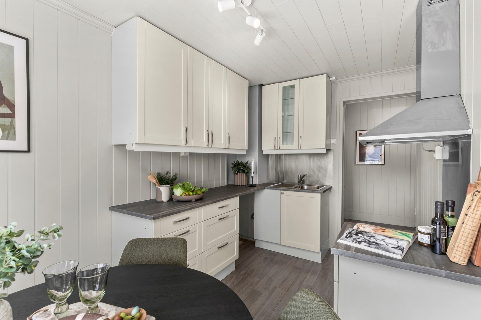 Kjøkkenet har innredning med profilerte fronter. Benkeplaten er av laminat med stålkum. Galleribilde