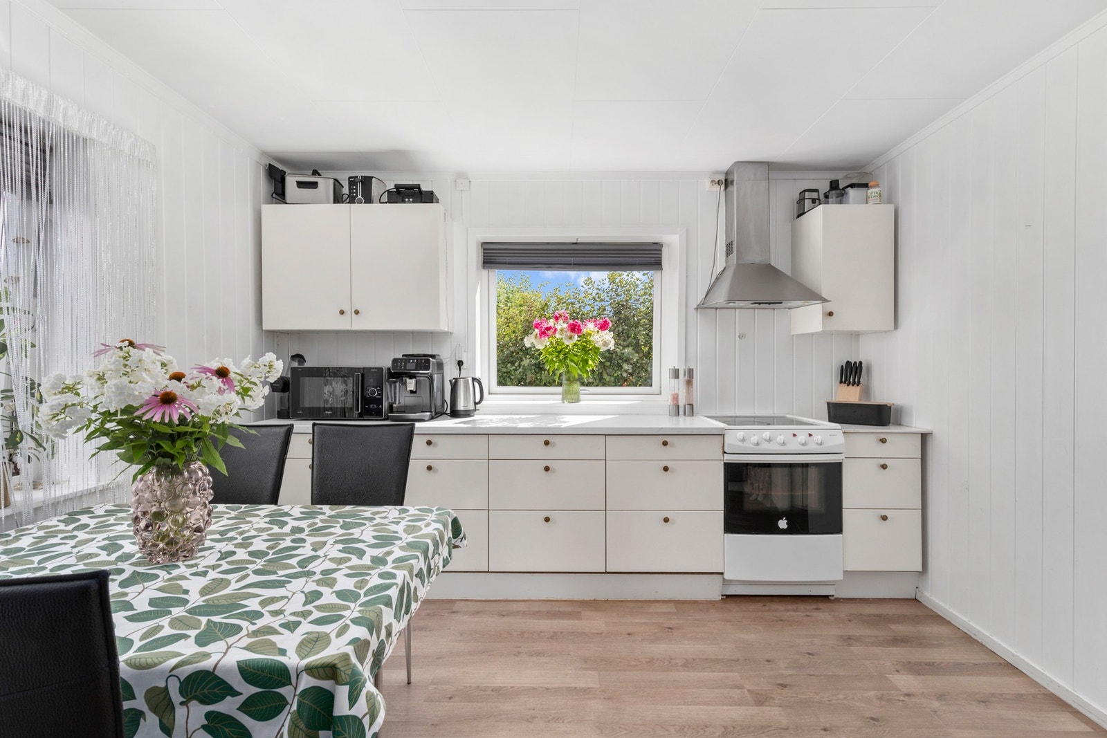 Kjøkkenet har innredning med profilerte fronter. Benkeplaten er av laminat med stålkum. Galleribilde