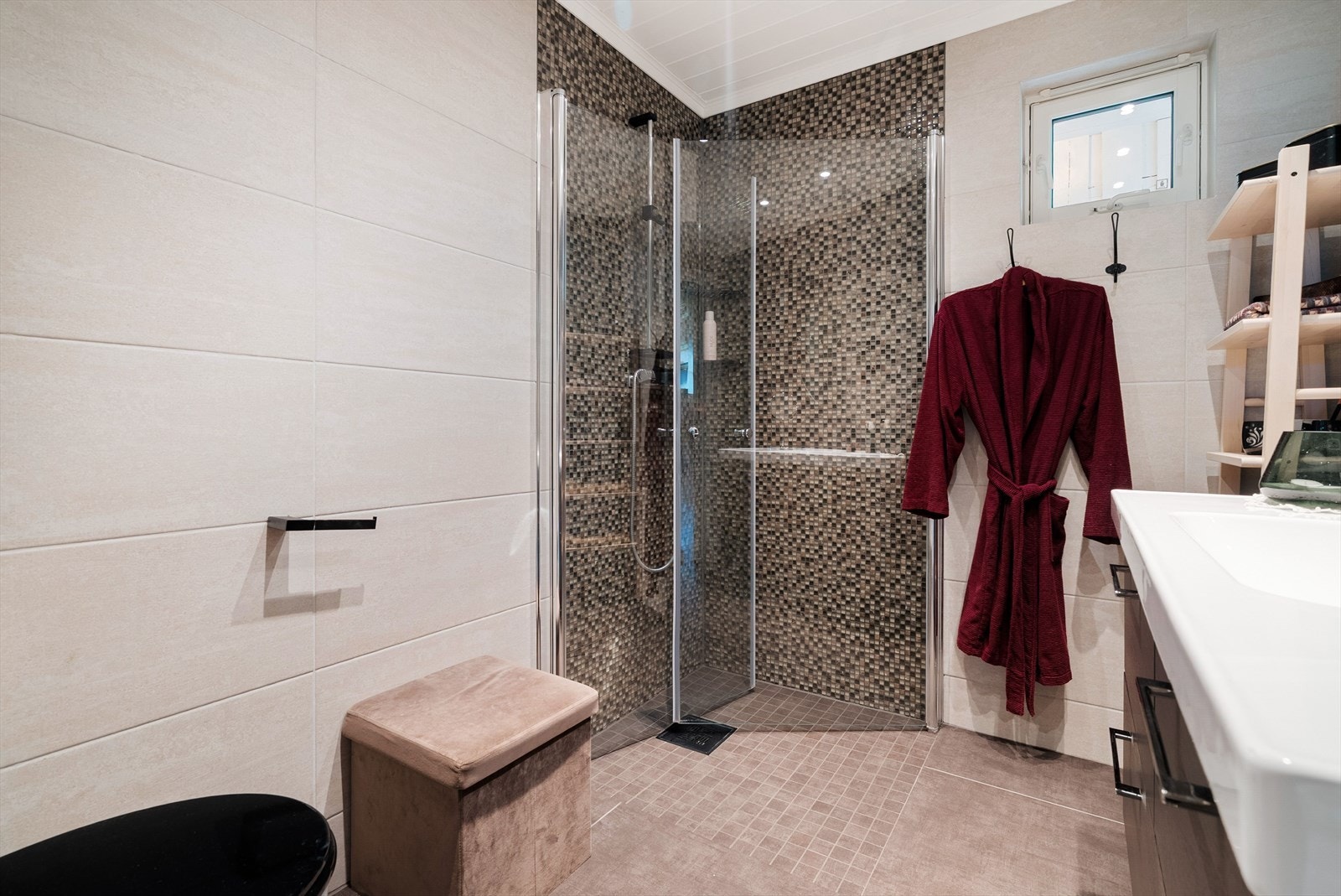 Badet i hovedetasjen er utstyrt med toalett, servantinnredning og dusjhjørne, mens et separat vaskerom gir praktisk plass til klesvask. Galleribilde