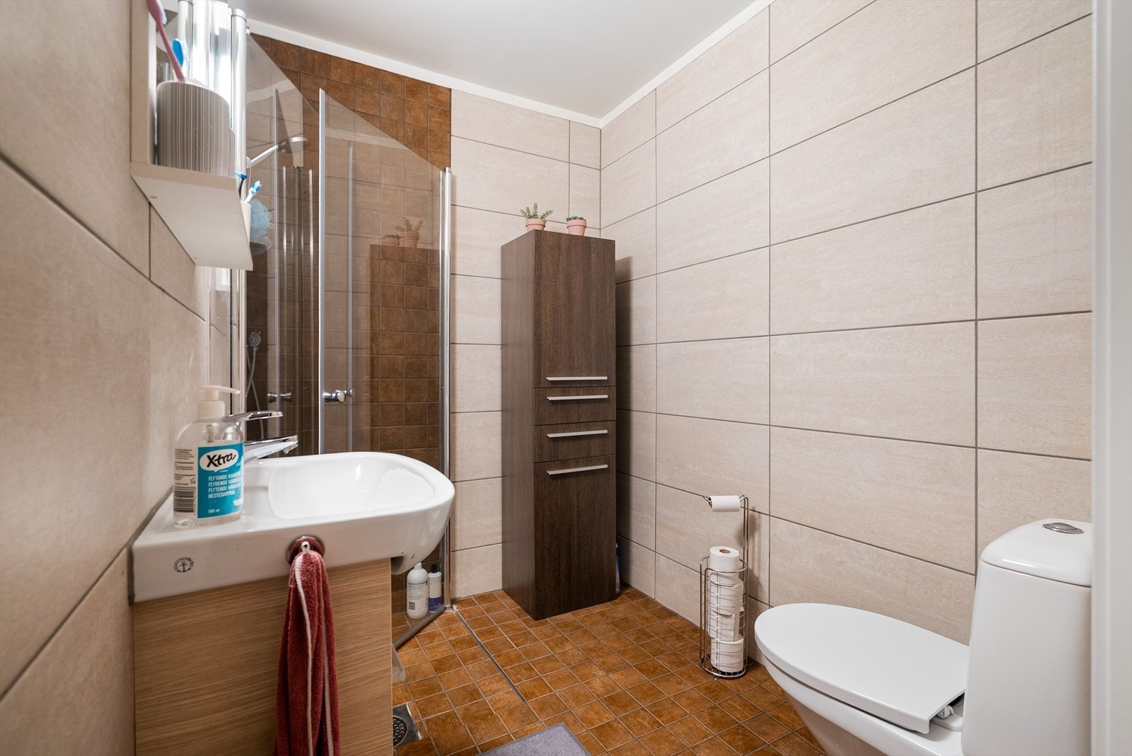 Badet er utstyrt med servantinnredning, toalett og dusjhjørne. Galleribilde
