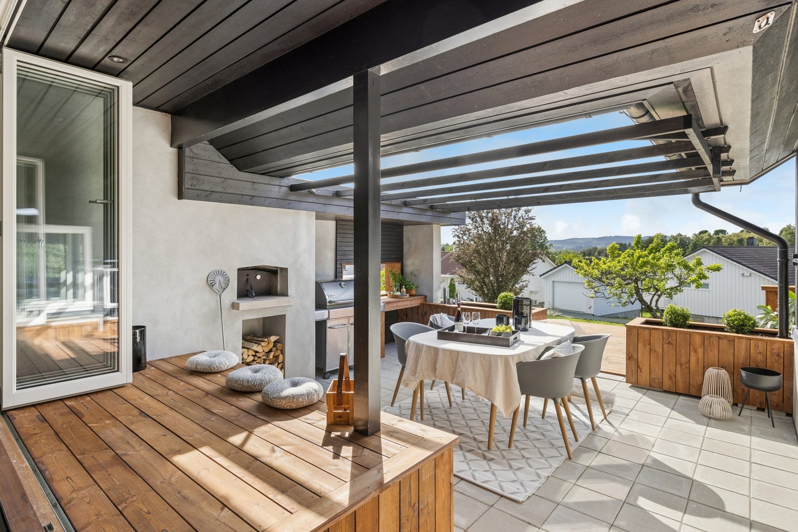 Uteplassen er boligens hjerte - en overdekket terrasse med italiensk pizzaovn, utekjøkken og lyslenker som innbyr til lange kvelder fra vår til høst. Uteplassen er samlingsarenaen, stor nok til at alle kan være ute samtidig uten at det føles trangt. Galleribilde