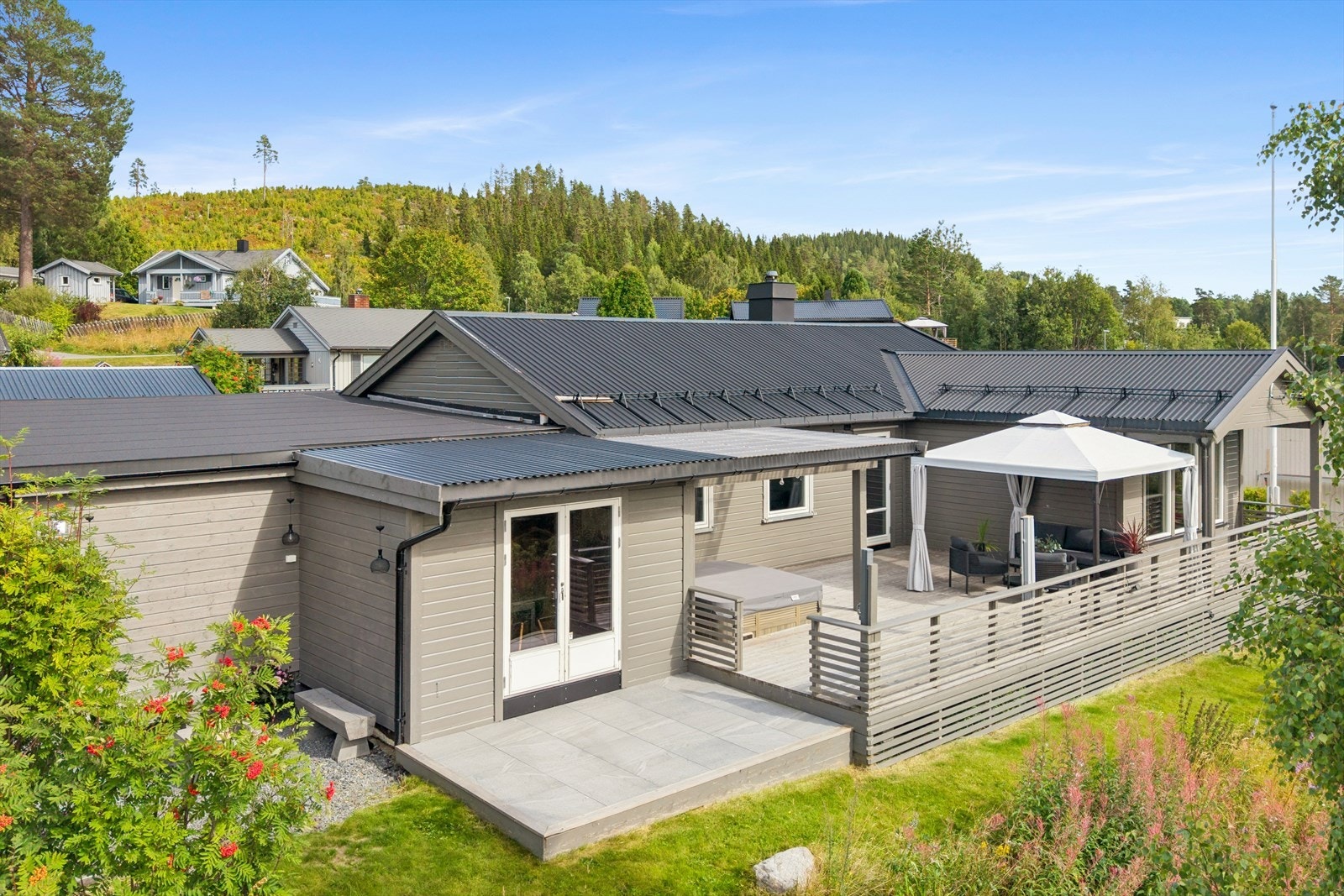 Uteområdet er pent opparbeidet med plen, beplantning og gruset gårdsplass. Galleribilde