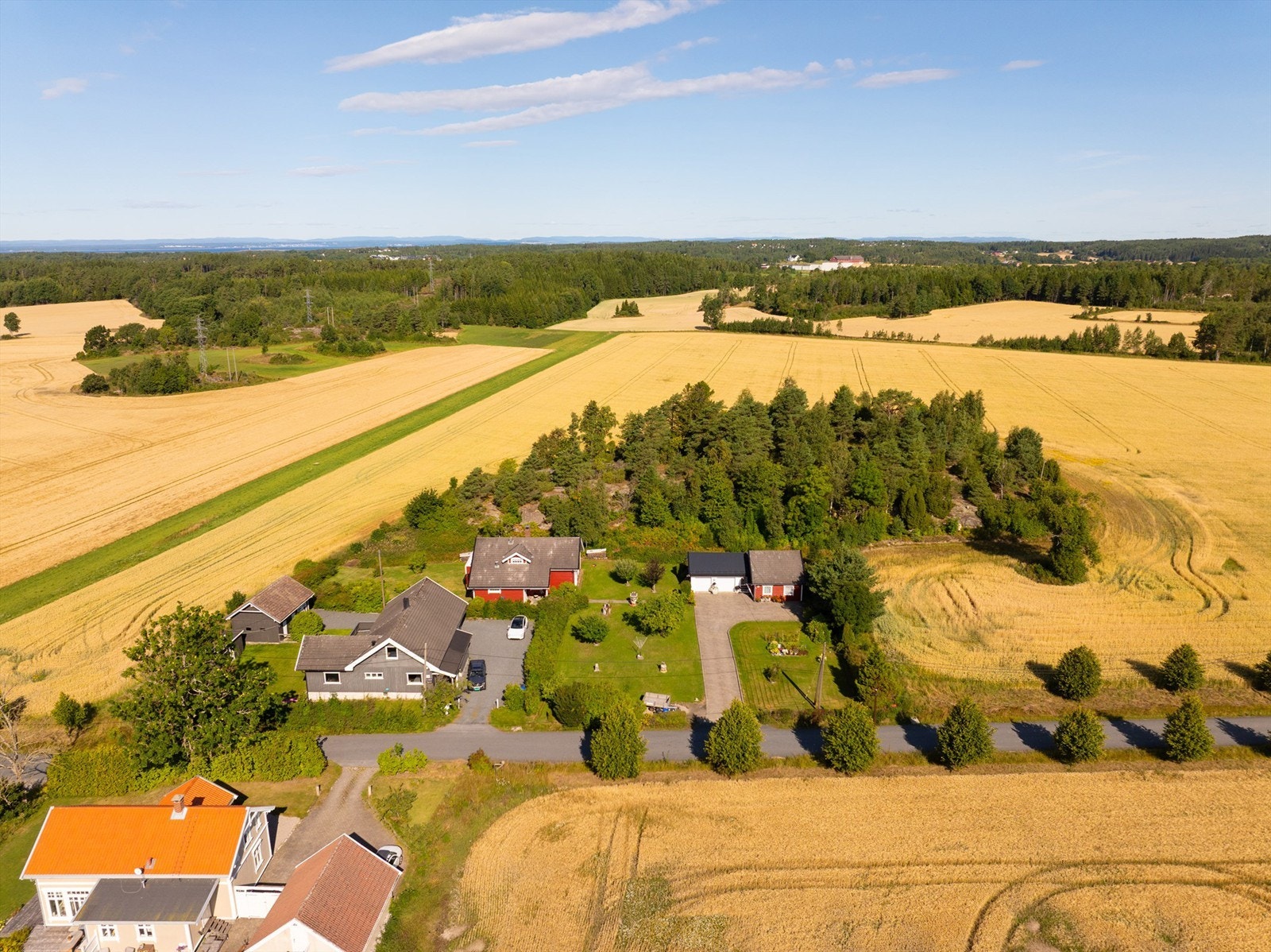 På tomten inngår del av åkeren som her sees til høyre, omtrentlig frem til åkerholmen. Galleribilde