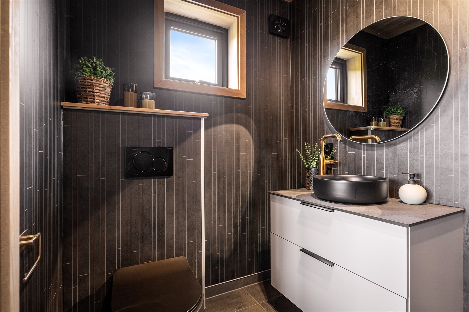 Badet fremstår moderne og delikat, med elegant baderomsmøblement, vegghengt toalett og en romslig dusj. Galleribilde