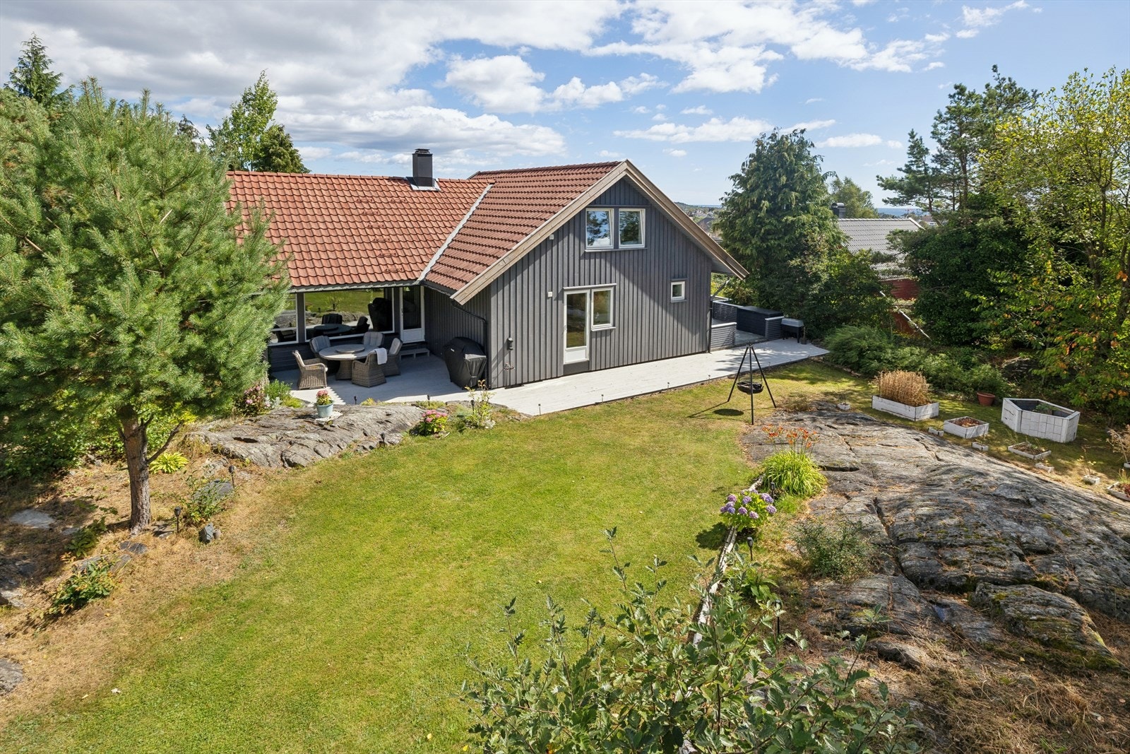 Tomten fremstår som romslig, velholdt og skjermet, med en hyggelig kombinasjon av natur og opparbeidede arealer. Galleribilde