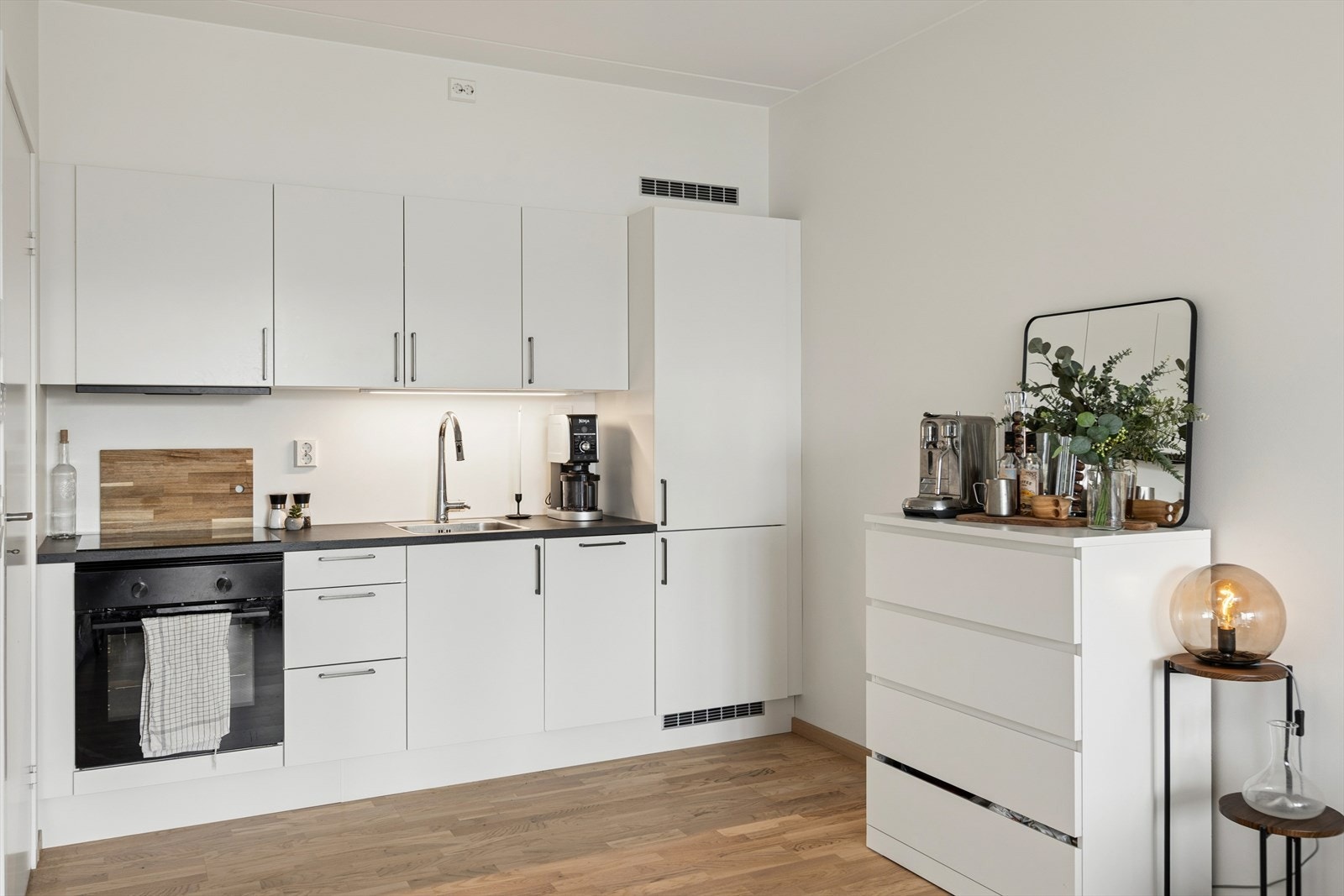 Kjøkkenet ligger i åpen løsning med stuen. Innredning med folierte skrog med slette fronter og laminert benkeplate. Galleribilde