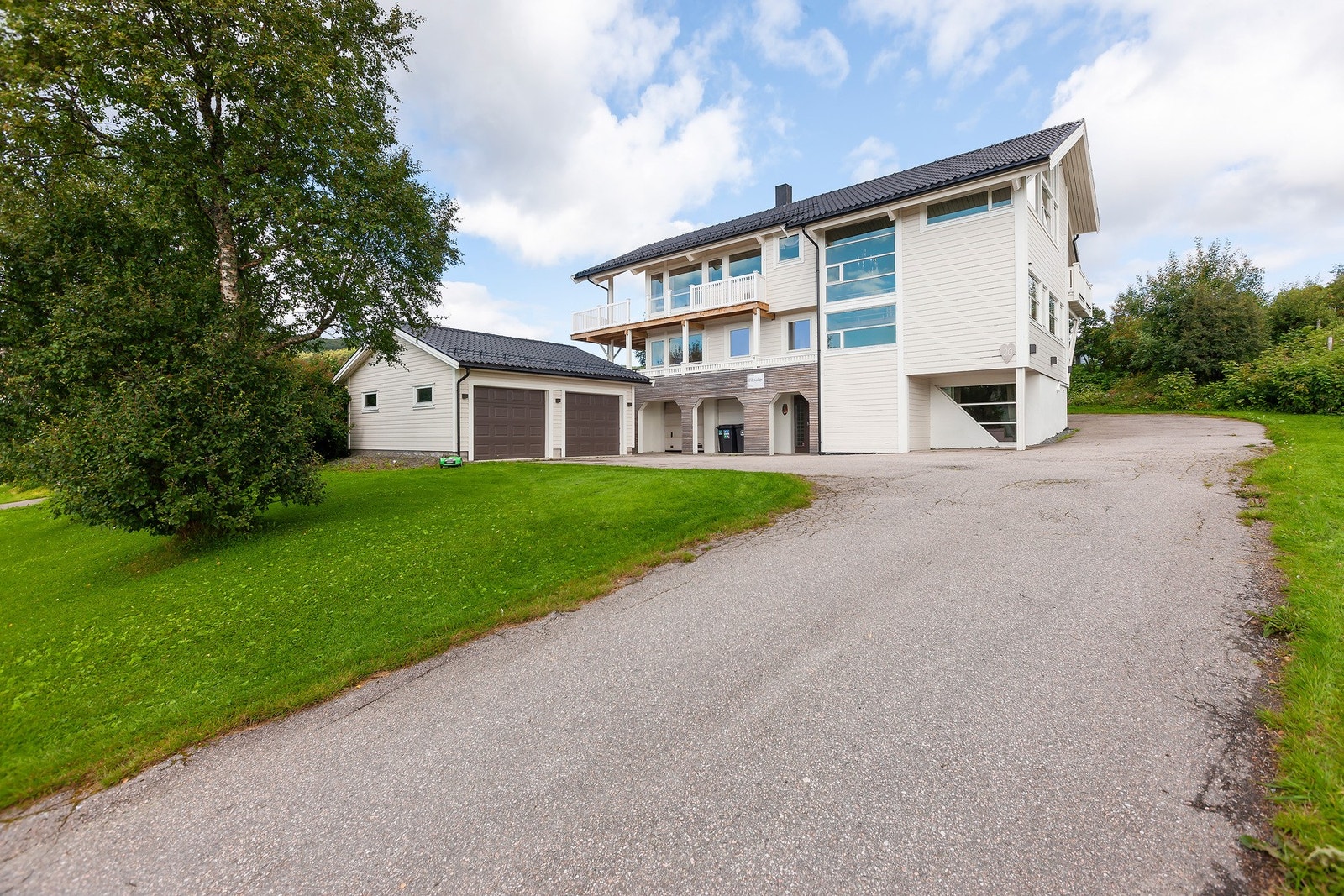Romslig, asfaltert gårdsplass med gode parkeringsmuligheter for flere biler. Galleribilde