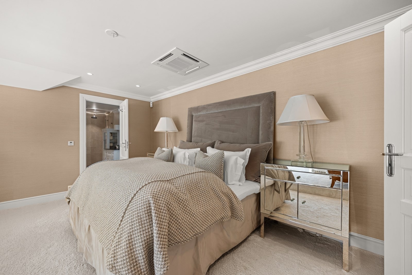 Suiten er innredet i delikate, beige nyanser med heldekkende teppe, innfelte downlights og god plass til både dobbelseng med tilhørende møblement og en egen stueavdeling. Galleribilde