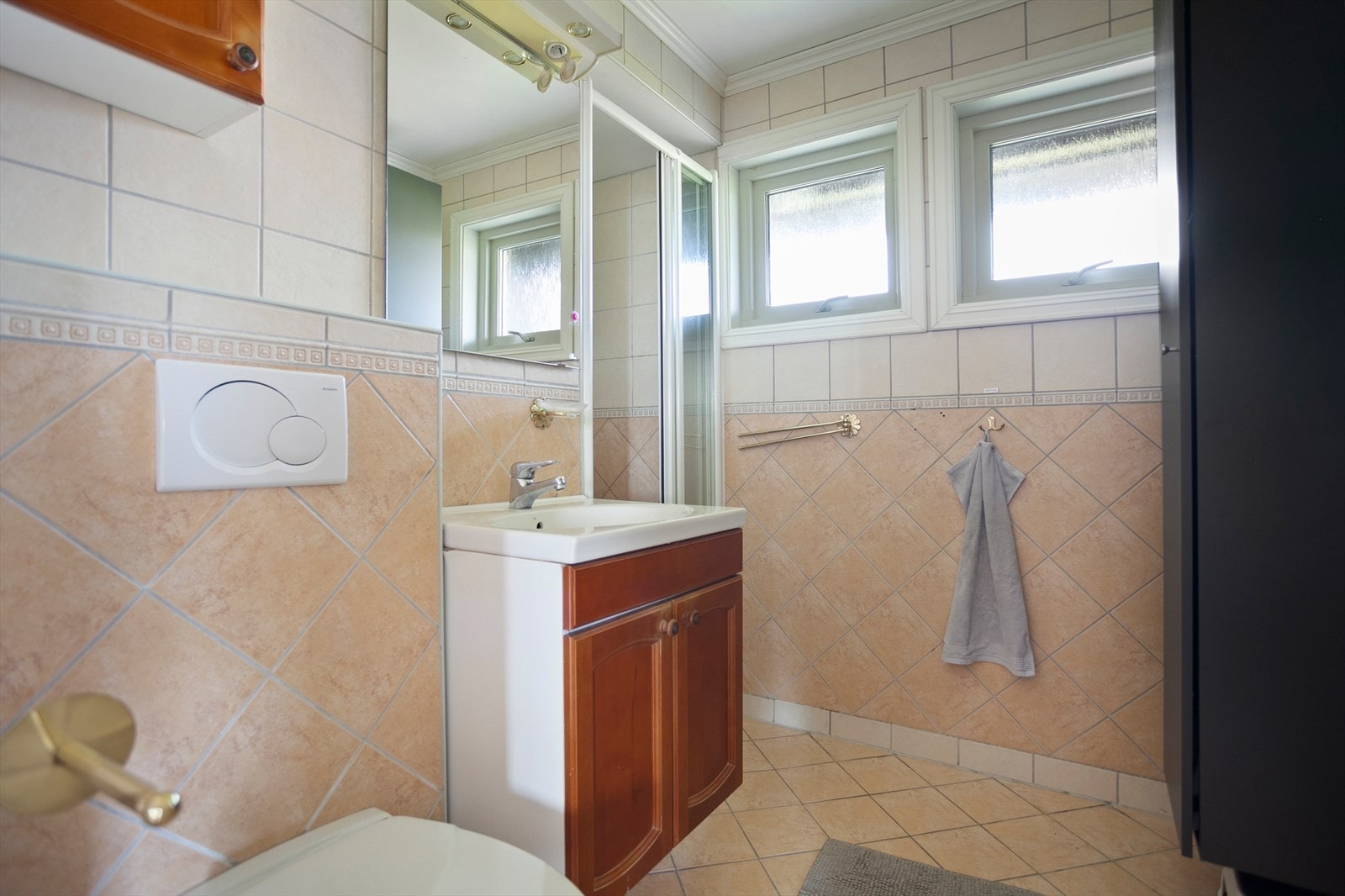Badet i hovedetasje er pusset opp i 2004. Det har flis på vegg, malt innvendig tak og flislagt gulv med elektriske varmekabler. Det ble lagt nye fliser i dusjsonen ca. 2016. Badet har innredning m/nedfelt servant, veggmontert toalett og dusjvegger/hjørne Galleribilde