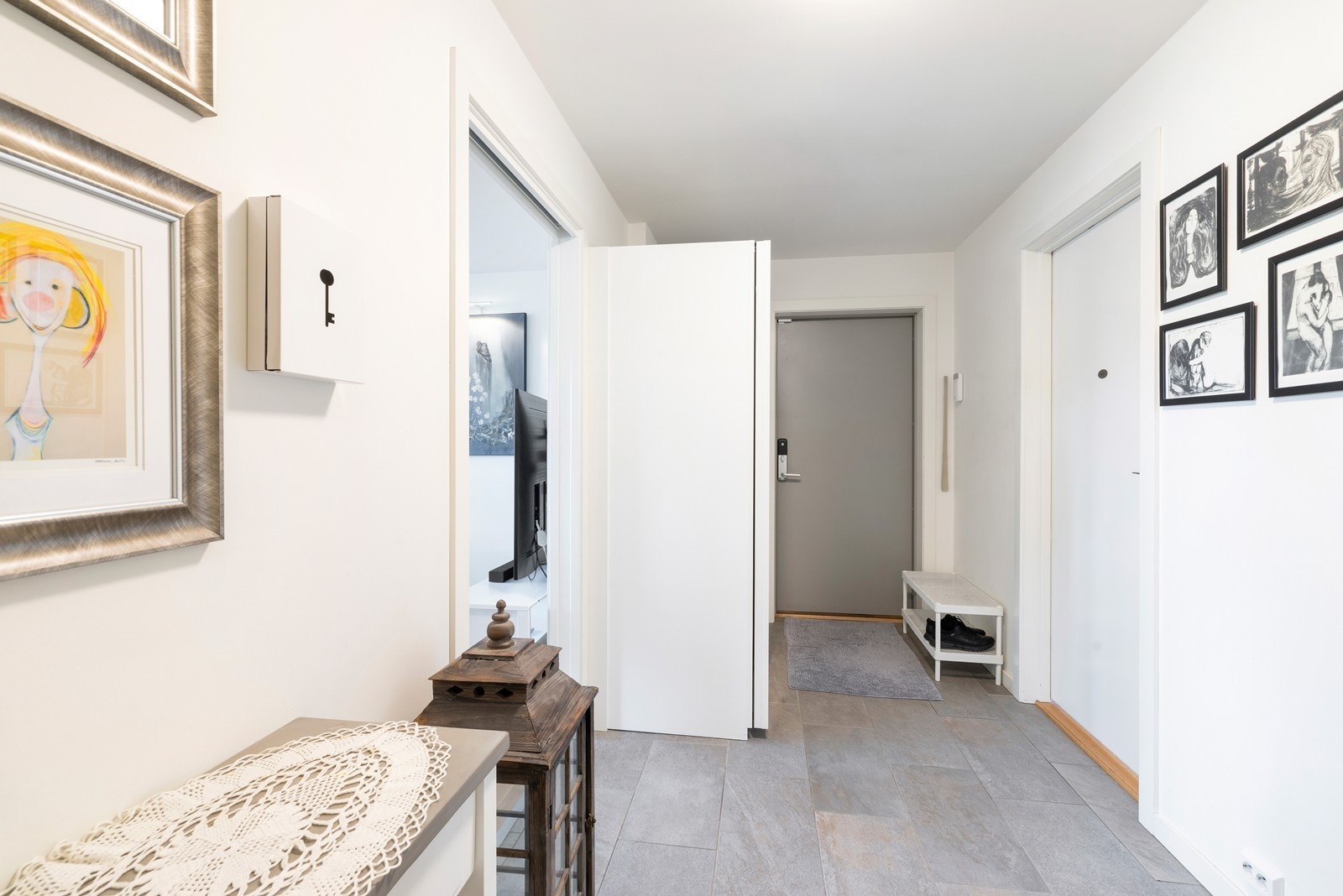 Gang med fliser på gulv og adkomst til stue, soverom og bad. Galleribilde