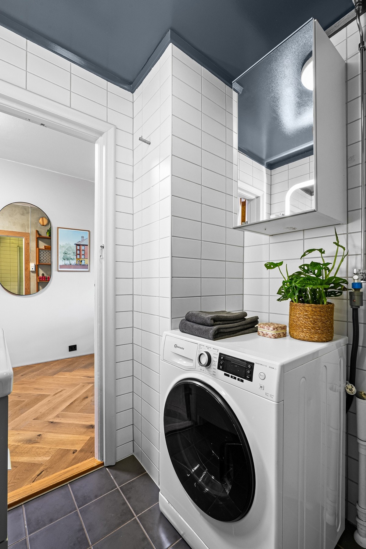 Badet har opplegg for vaskemaskin og det er lagring i et overhengt skap. Galleribilde