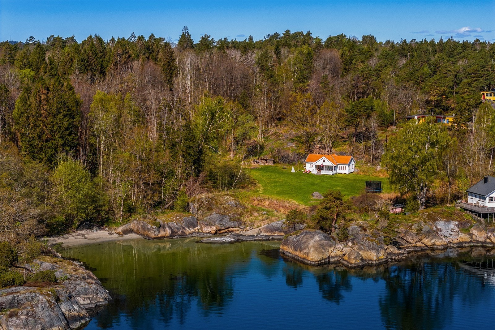 Hytta ligger fint for seg selv med gresslette som strekker seg ned mot sjøen med sandstrand og svaberg. Galleribilde