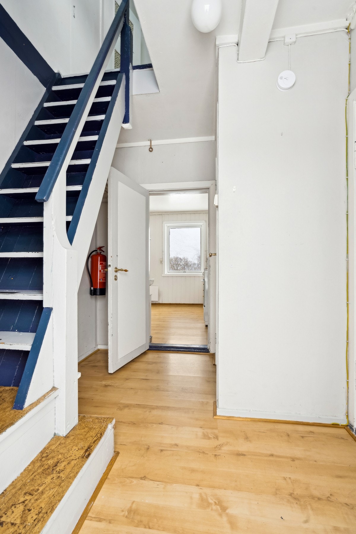 Entré med malt tretrapp som leder opp til loftsetasjen. Galleribilde
