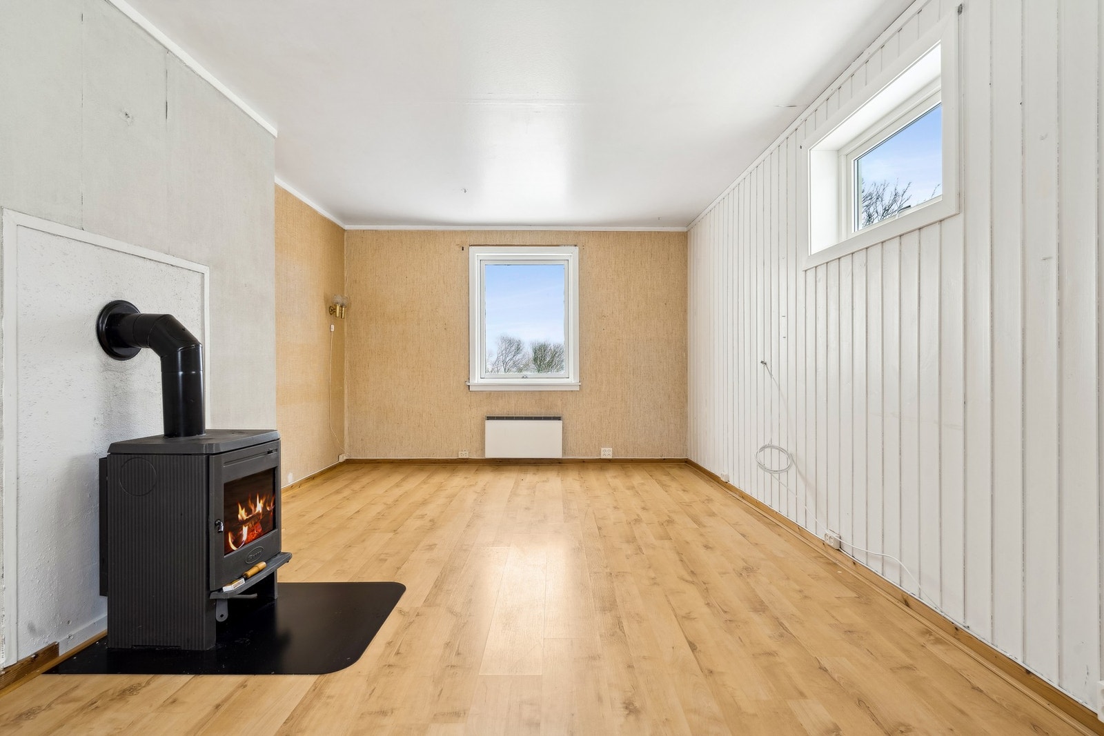 Stuen er utstyrt med vedovn tilknyttet mursteinspipe for ekstra varme. Galleribilde