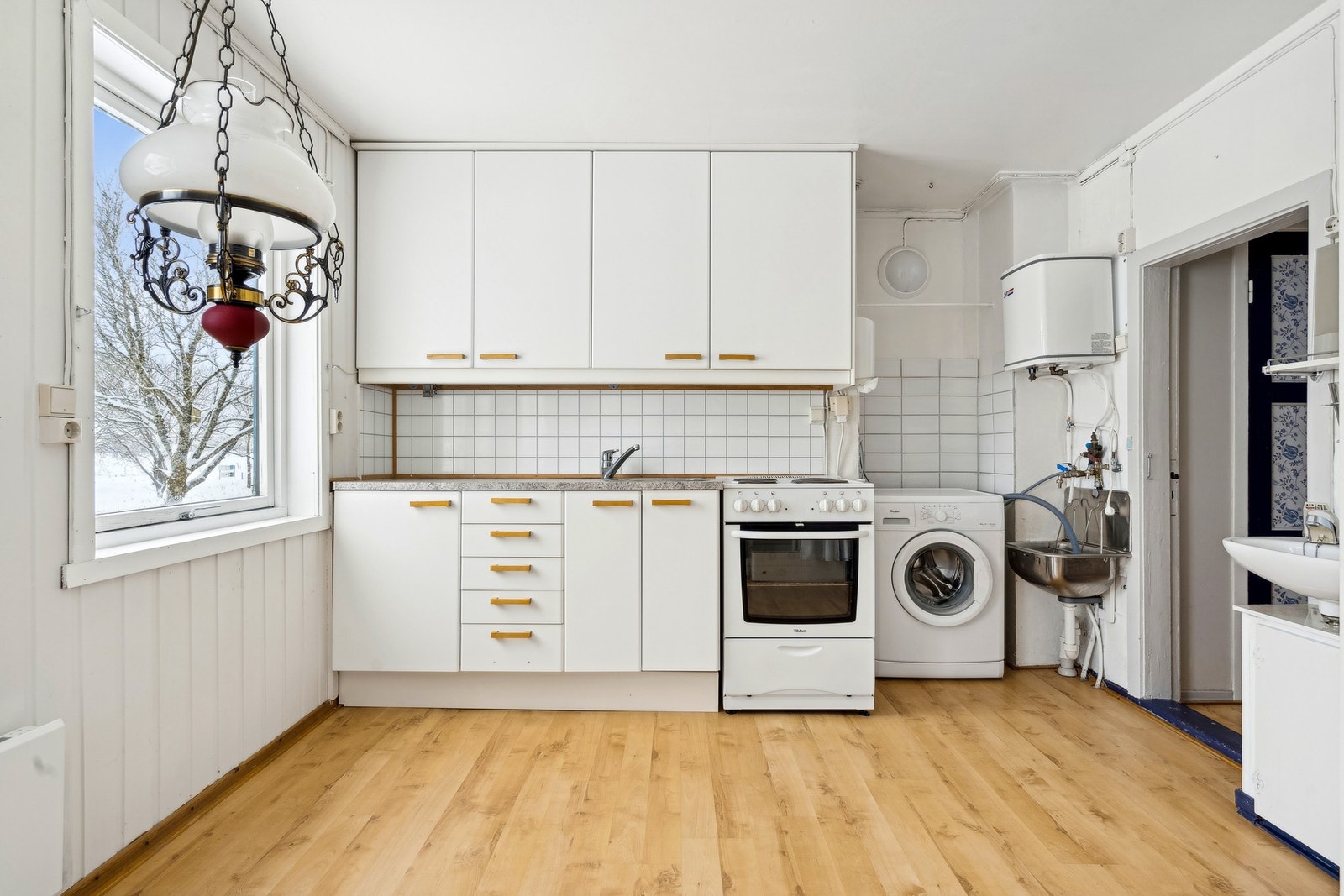 Rommet har opplegg for vaskemaskin og et praktisk vaskekar i stål. Galleribilde
