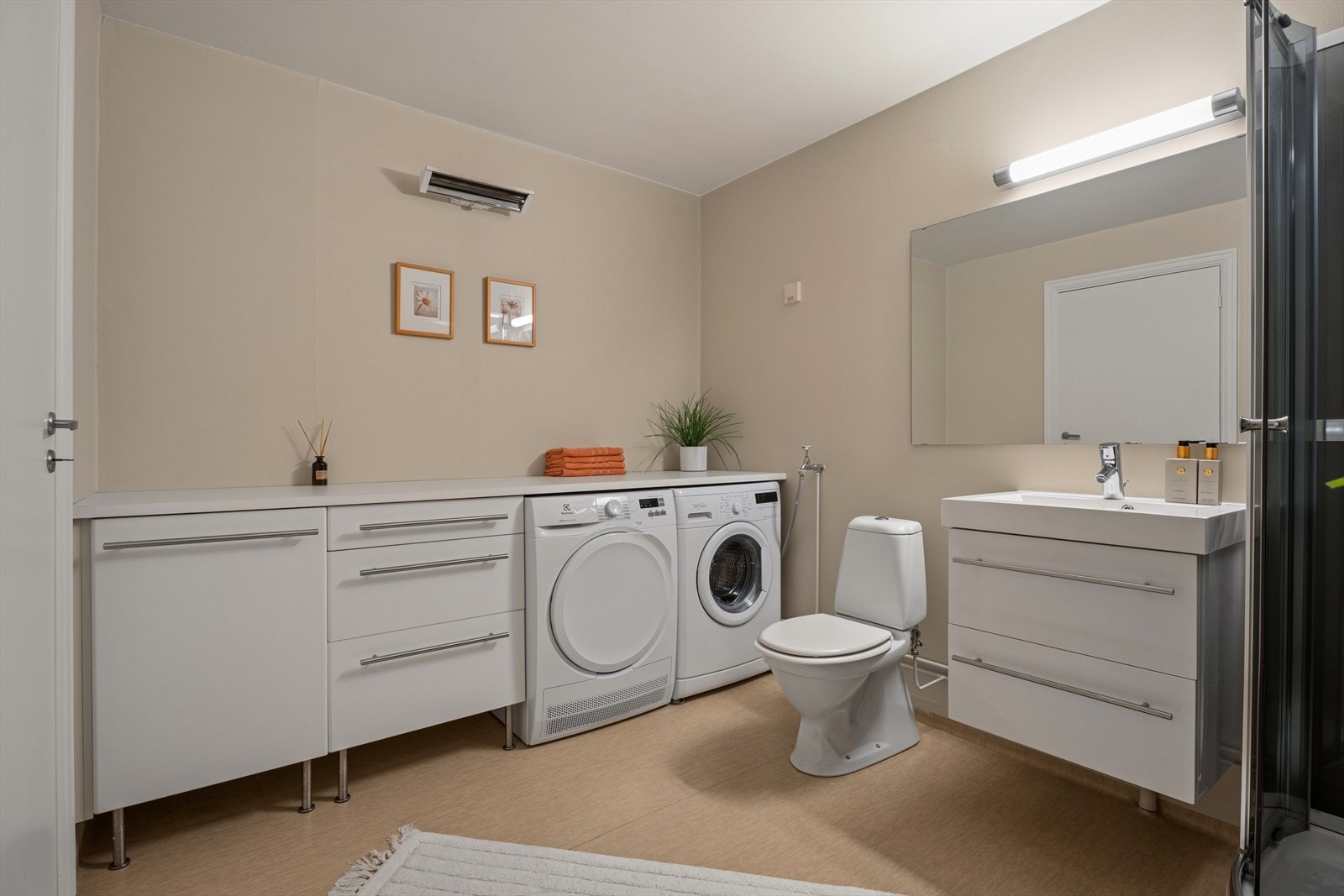 Badet er fra byggeåret og har vinylbelegg på gulv samt malte veggflater. Rommet er innredet med baderomsinnredning med skuffer og heldekkende servant med ett-greps blandebatteri. Over servanten er det montert speil med integrert belysning. Galleribilde
