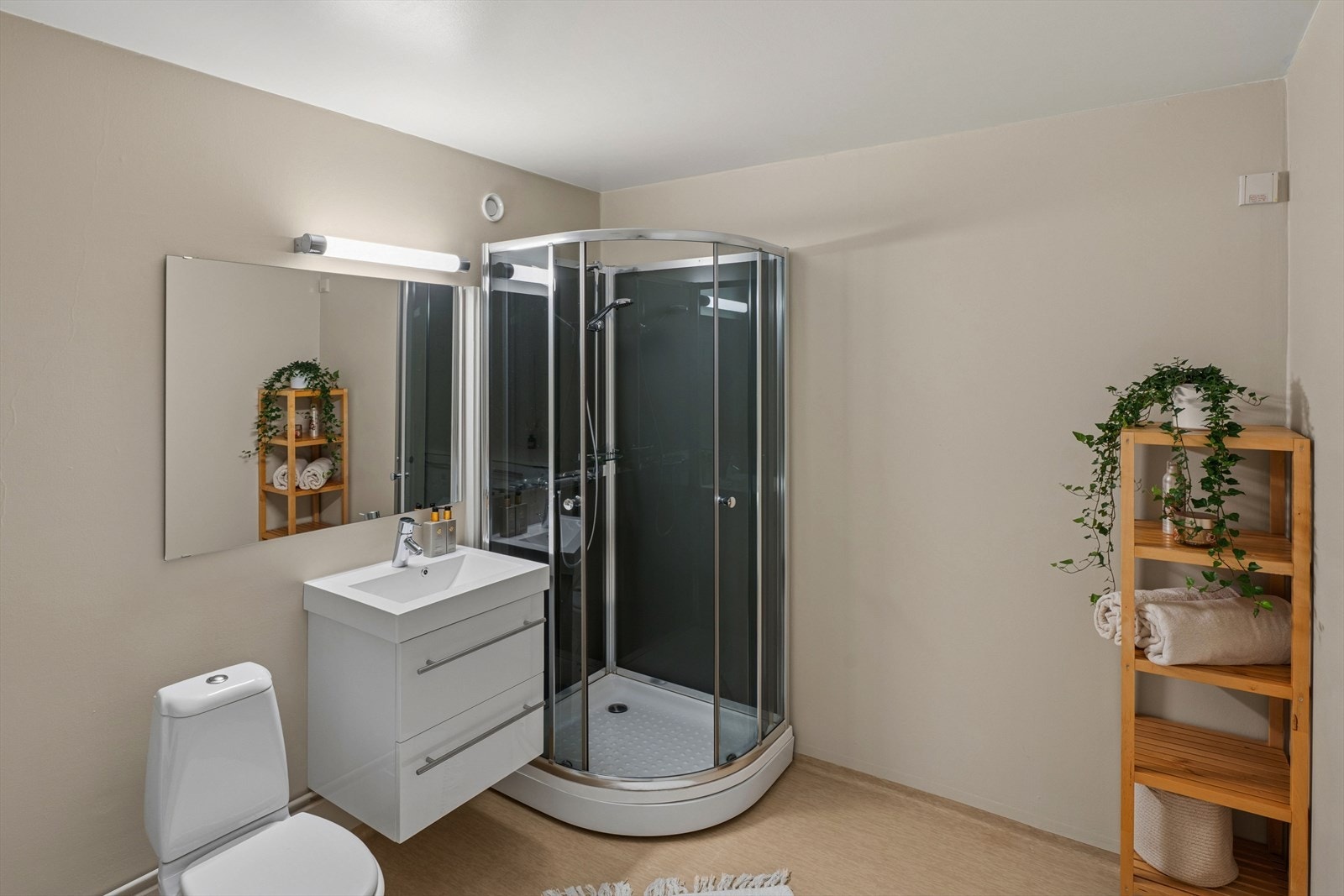 Videre er det innredning med laminert benkeplate, underskap samt opplegg og plass til både vaskemaskin og tørketrommel. I tillegg er badet utstyrt med dusjkabinett med glassdører og håndholdt dusjgarnityr, samt gulvmontert toalett. Galleribilde