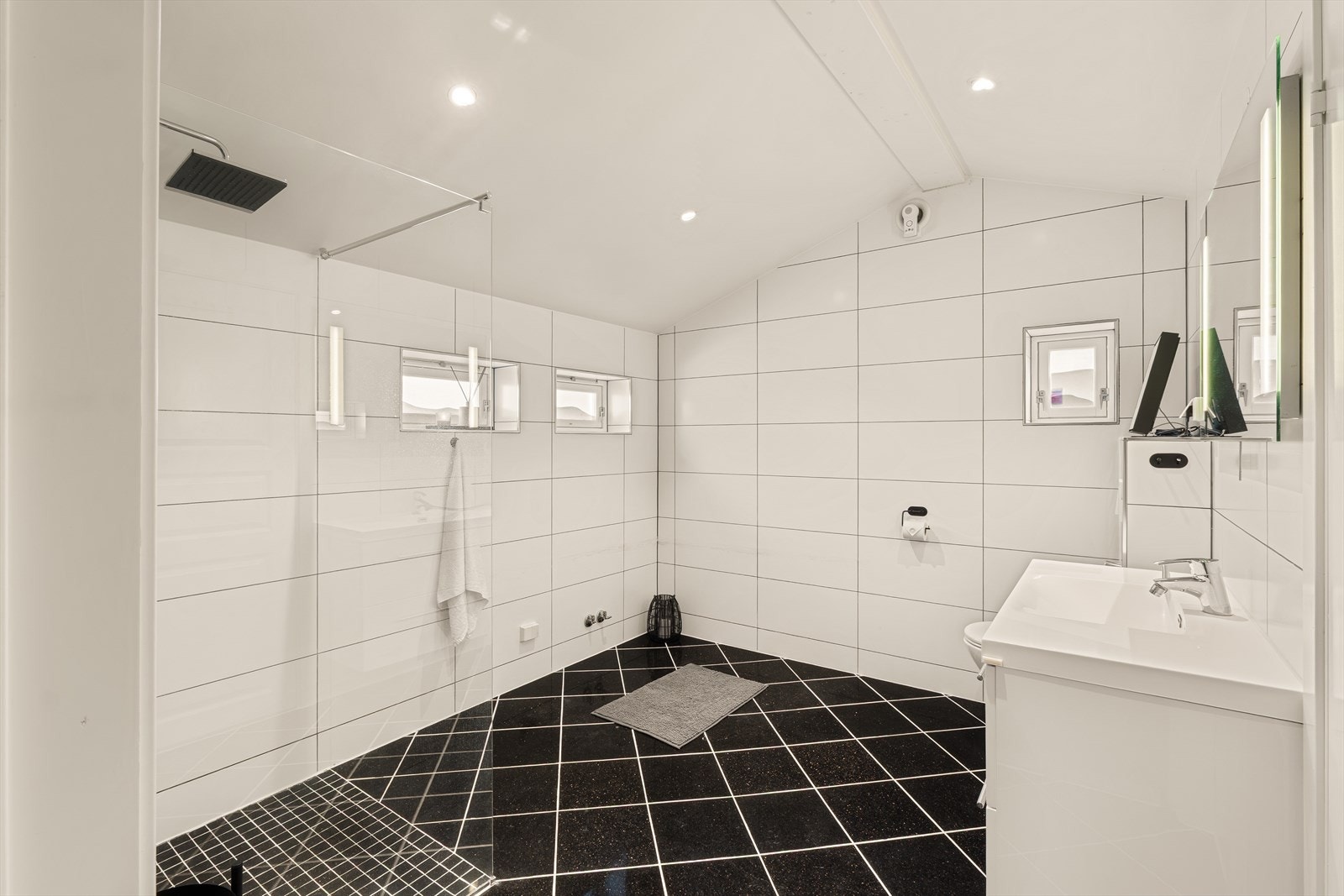 Badet er helfliset med varmekabler i gulvet. Rommet er pusset opp i 2017. Det har tidligere stått et badekar i hjørnet. Galleribilde