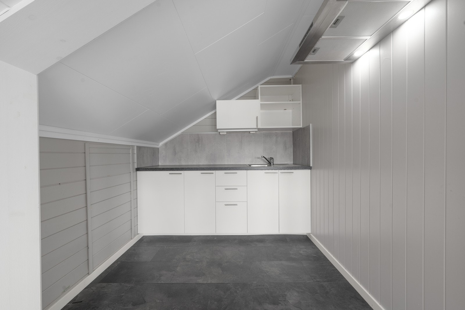 Kjøkkenkrok i loftsetasjen med hvite, slette fronter og laminatbenkeplate. Galleribilde