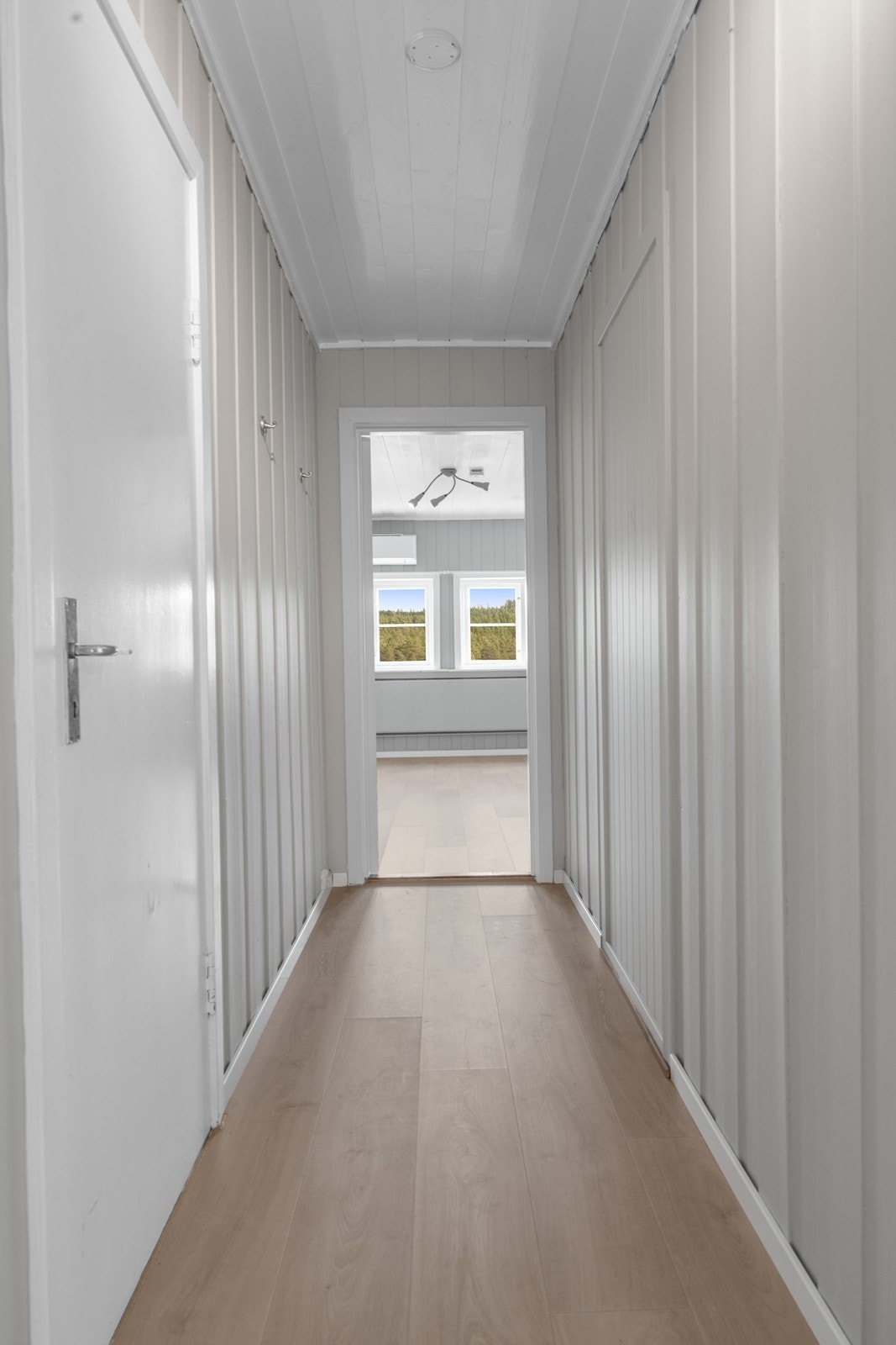 Gang i loftsetasjen med laminatgulv og malte panelvegger. Galleribilde