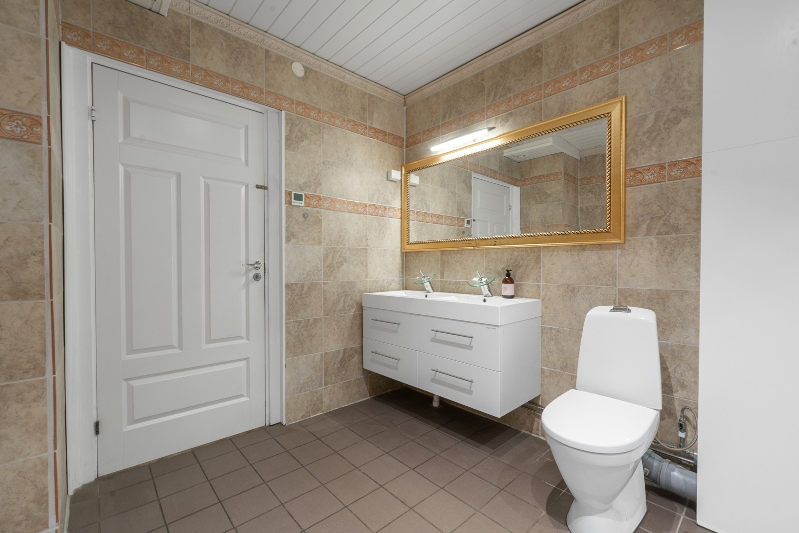 Badet er utstyrt med dusjkabinett og gulvmontert toalett. Galleribilde