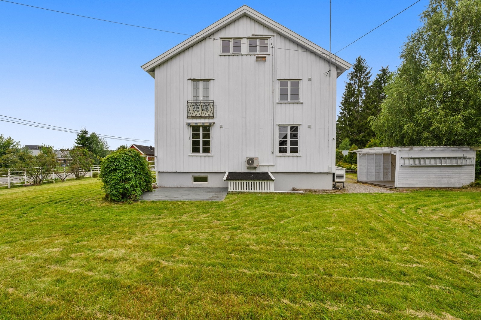 Stor og opparbeidet hage med gressplen, trær og diverse beplantning. Galleribilde