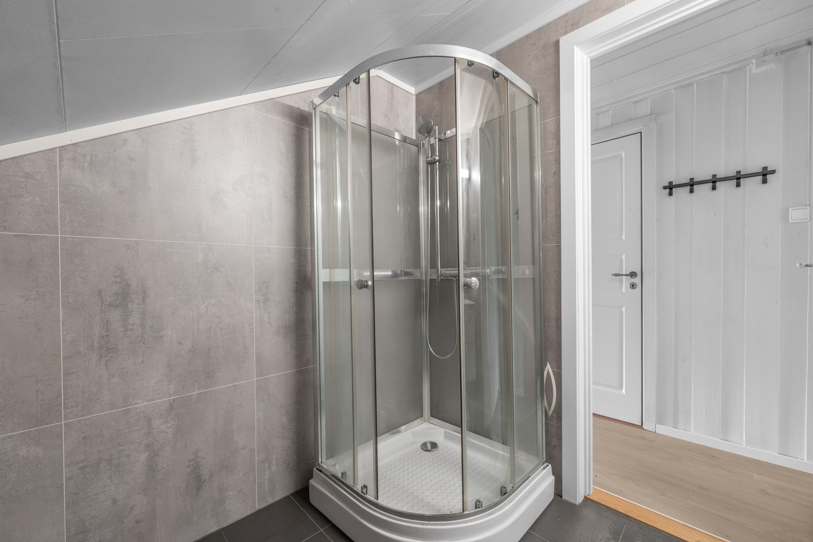 Badet er utstyrt med dusjkabinett med glassdører. Galleribilde