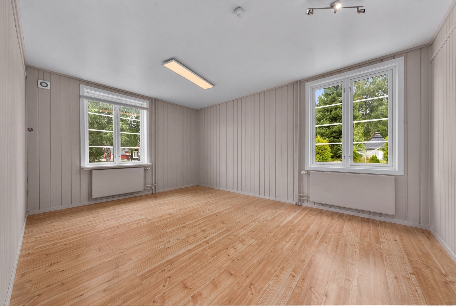 Stort rom med tregulv og vinduer som slipper inn rikelig med dagslys. (Digitalt ryddet foto, avvik kan forekomme) Galleribilde
