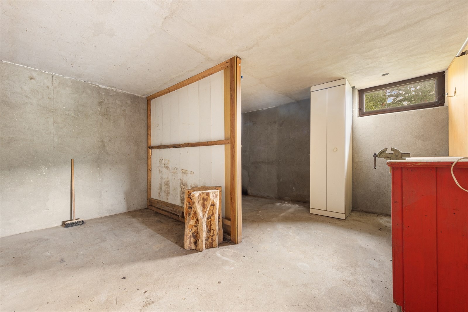 En av de romslige bodene i kjelleretasjen, med gulv av betong. Galleribilde