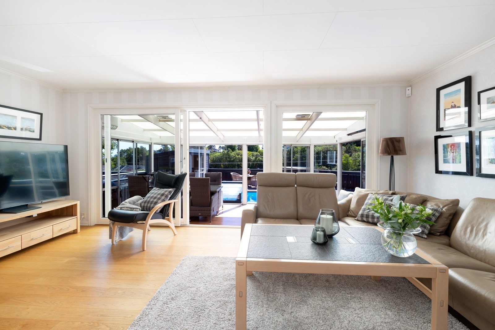 Lys og fin stue med plass til sofagruppe. Utgang til hagestue som fører deg til bassengområdet. Galleribilde