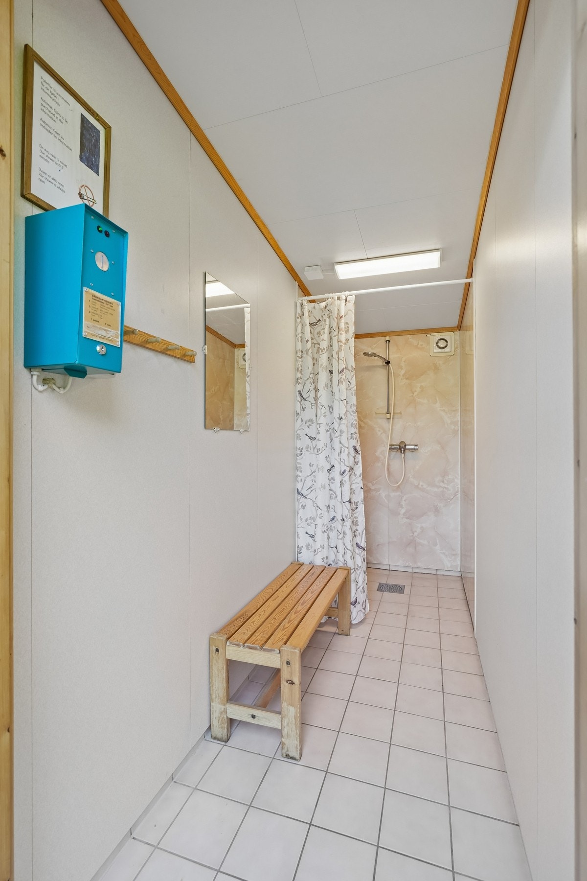 Dusjrom med flislagt gulv, dusjforheng og benk. Galleribilde