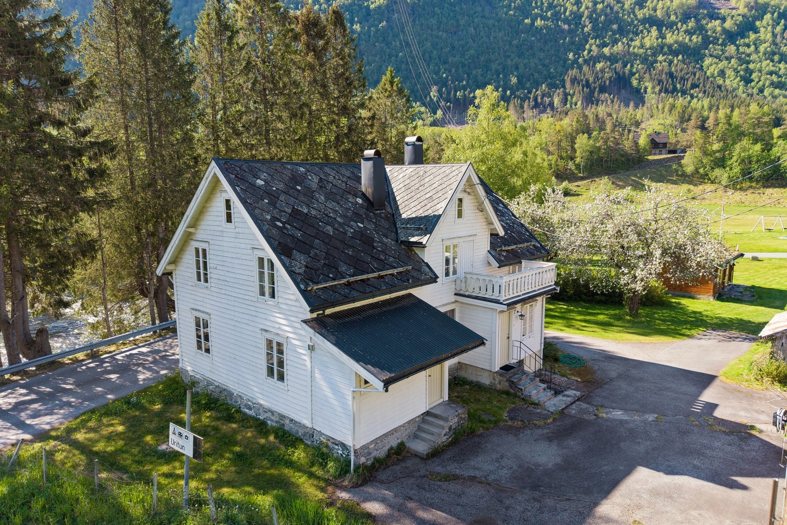 En romslig gårdsplass og vakkert tun med morelletrær og annen beplanting. Galleribilde