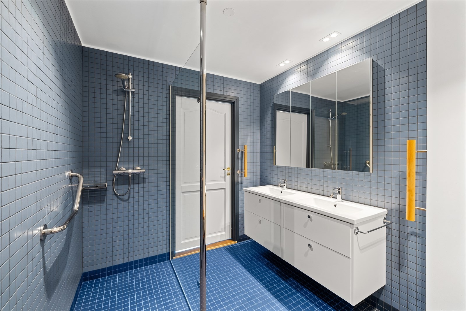 Den gjennomgående bruken av blåtoner kommer også til uttrykk på badet, med flotte mosaikkfliser på gulv og vegger. Galleribilde