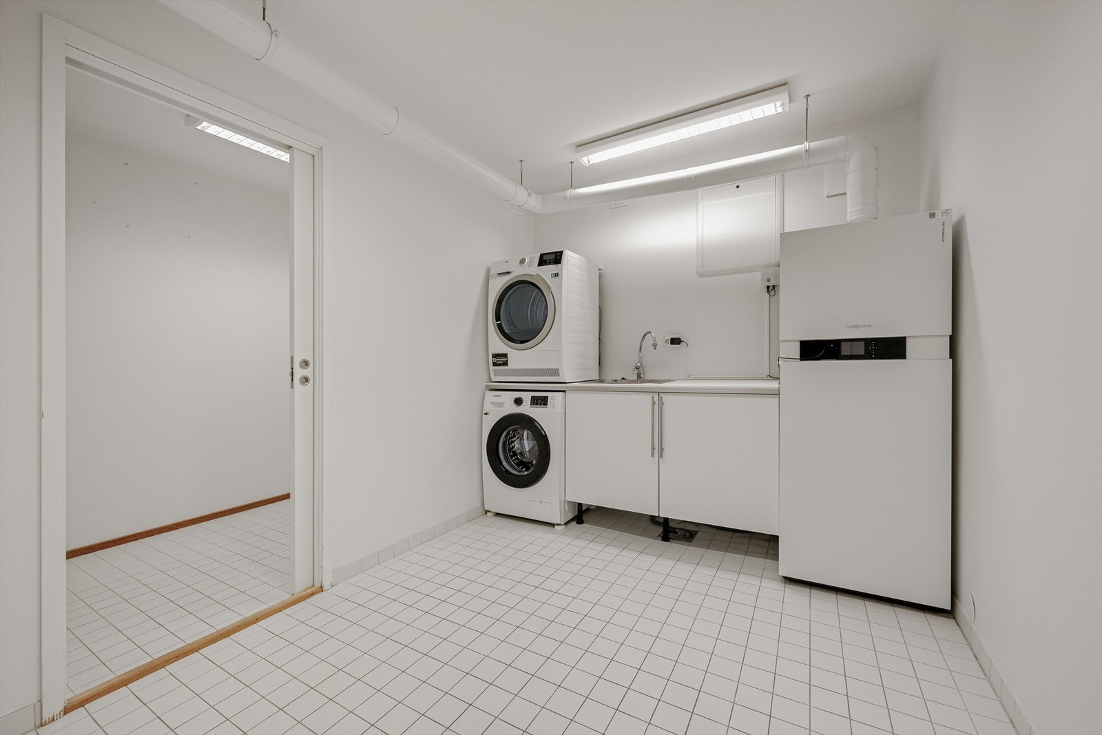 Separat vaskerom med utslagsvask og opplegg for vaskemaskin og tørketrommel. Galleribilde