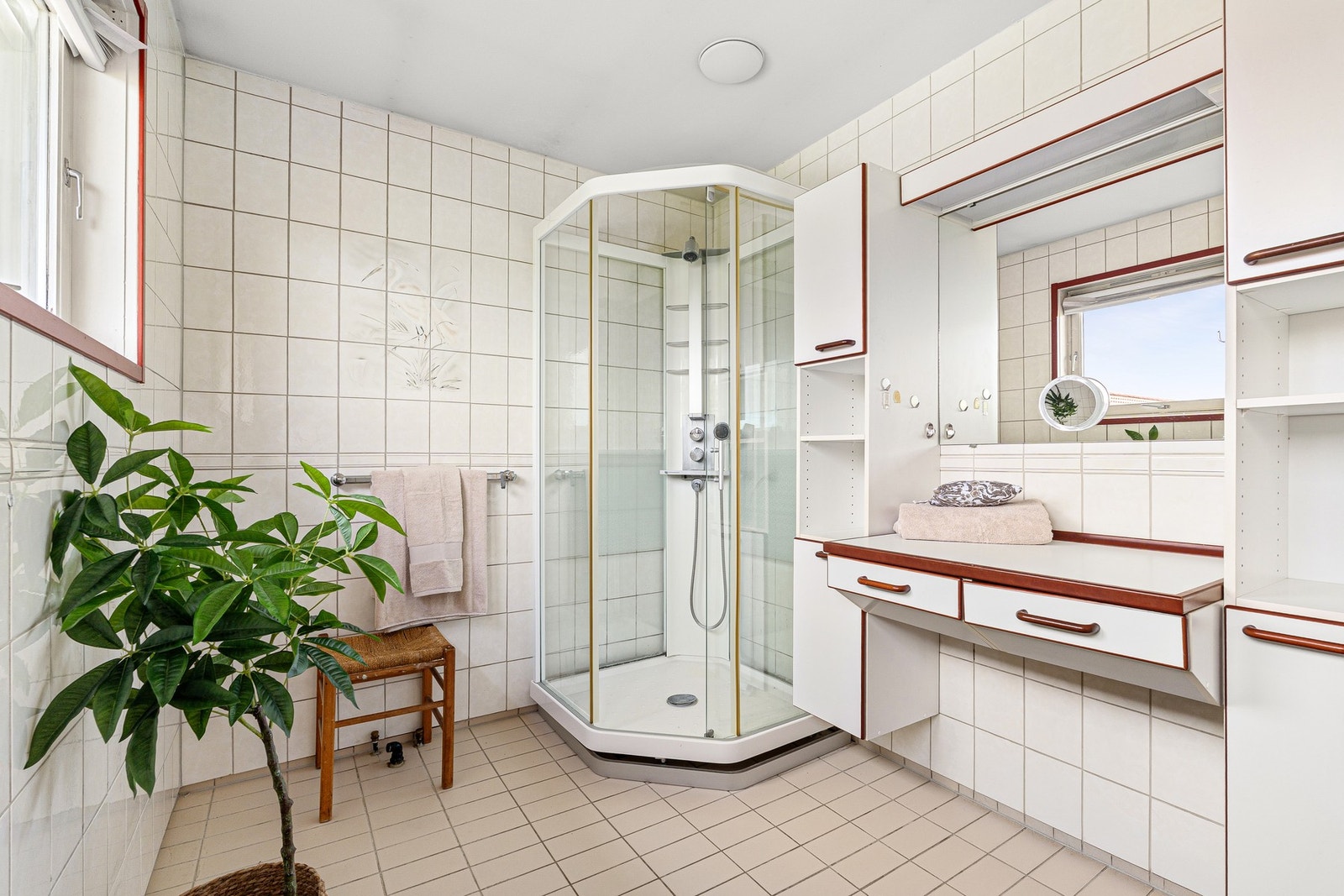 Pent baderom med flislagte overflater og god oppbevaring. Galleribilde