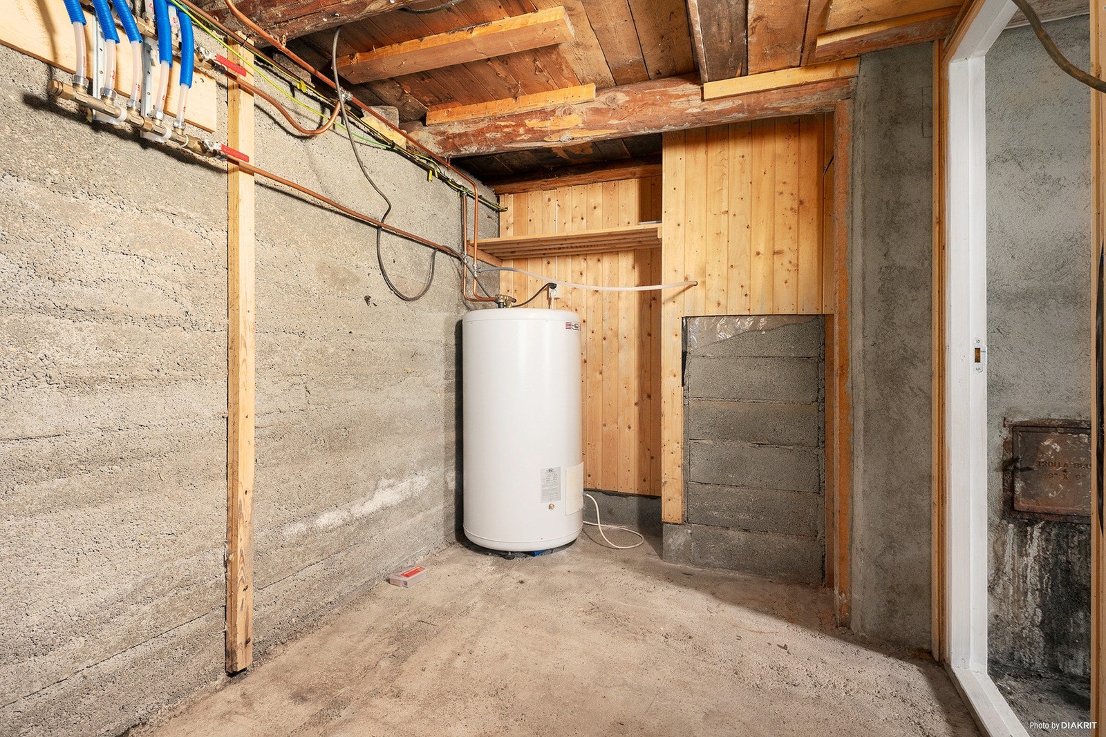 Varmtvannsbereder på ca. 200 liter og samlestokk for rør-i-rør-system i kjelleren. Galleribilde