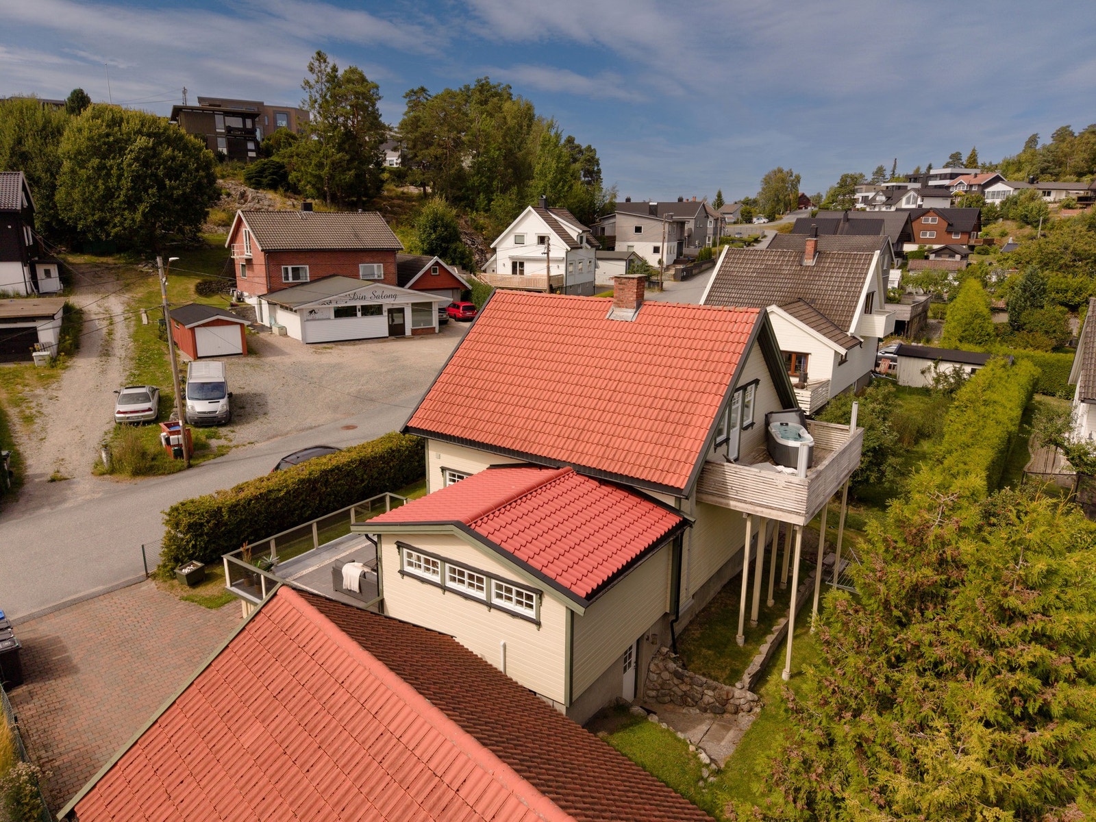 Fasade bakside. Hekk rammer inn eiendommen og skaper lite innsyn inn i hagen. Balkong er skjermet mot øst og har lèvegger for mindre innsyn. Galleribilde