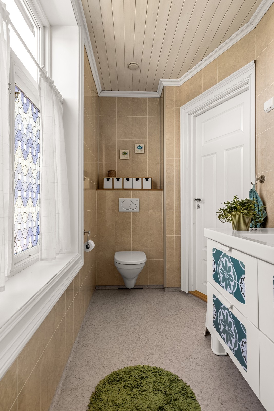 Badet er utstyrt med vegghengt toalett, servantinnredning og dusjhjørne. Galleribilde