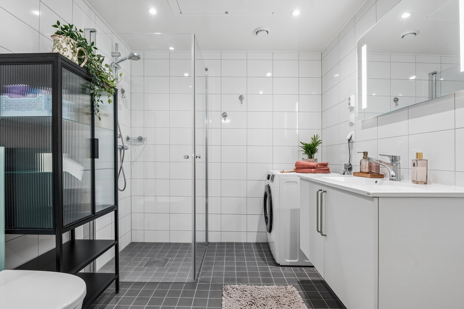 Leilighetens hovedbad har opplegg for vaskemaskin og downlights i taket. Galleribilde