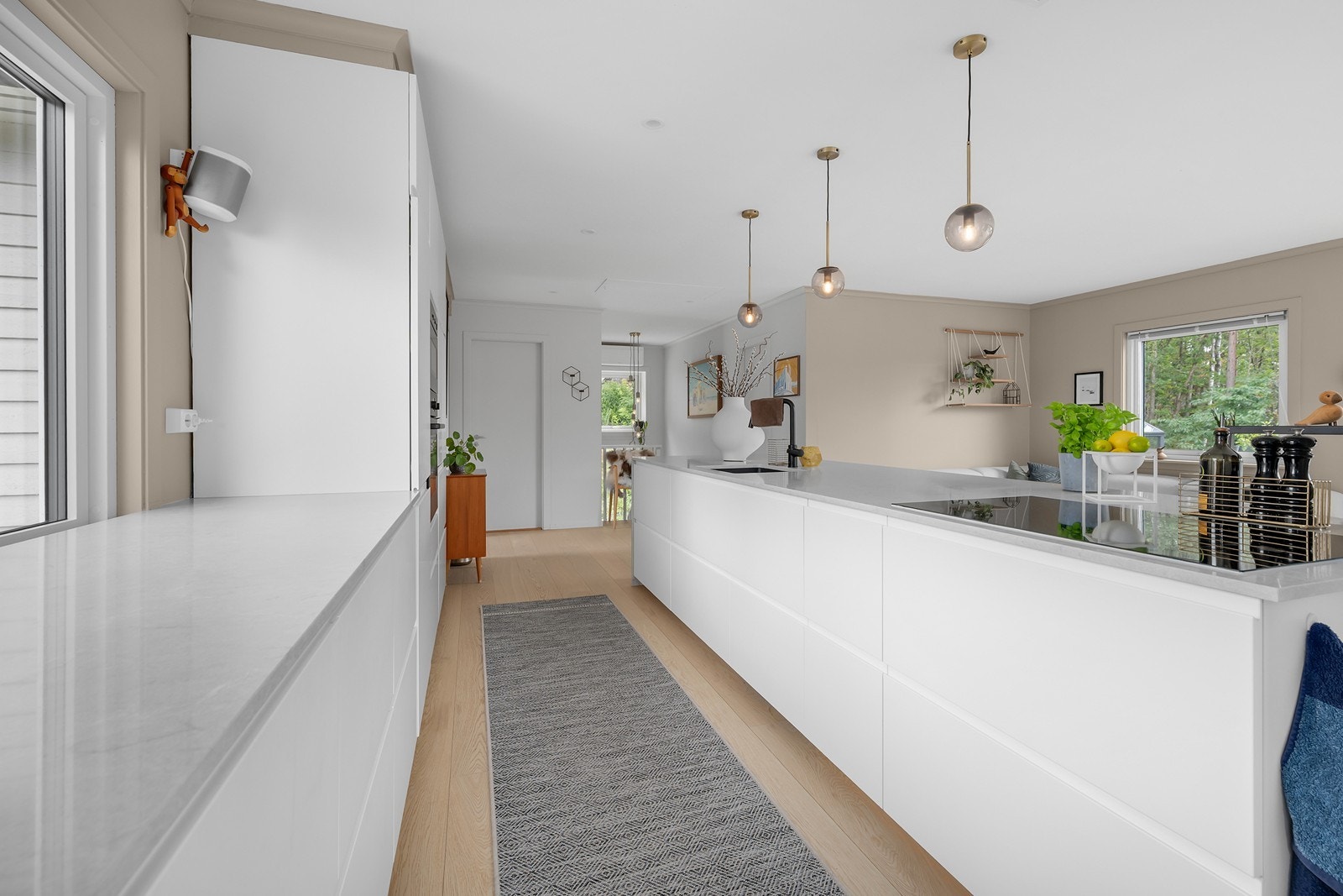Flott kjøkken i lys utførelse og caesarstone benkeplate. Integrerte hvitevarer. Galleribilde