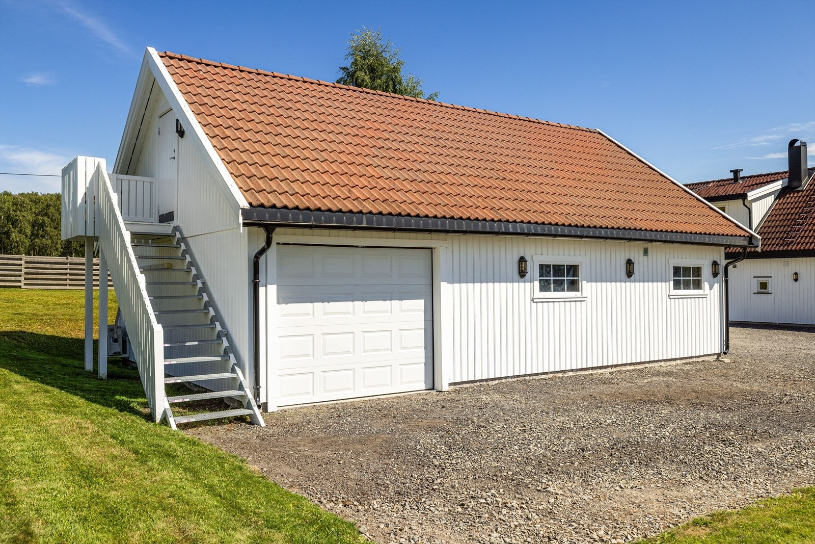 Enkelport på siden av garasjen, samt trapp opp til innredet hems. Galleribilde