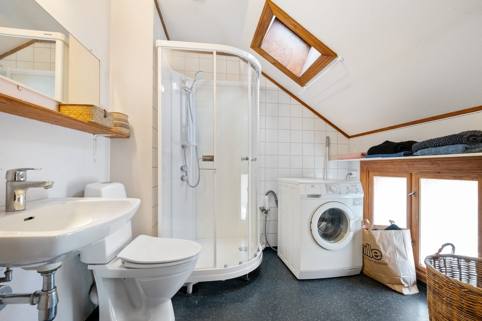 Belegg på gulv, og flis og malt overflate på vegger. Malt overflate i himling. Panelovn. Utstyrt med naturlig avtrekk, opplegg for vaskemaskin, dusjkabinett, wc og servant med ett greps blandebatteri fra Oras. Galleribilde