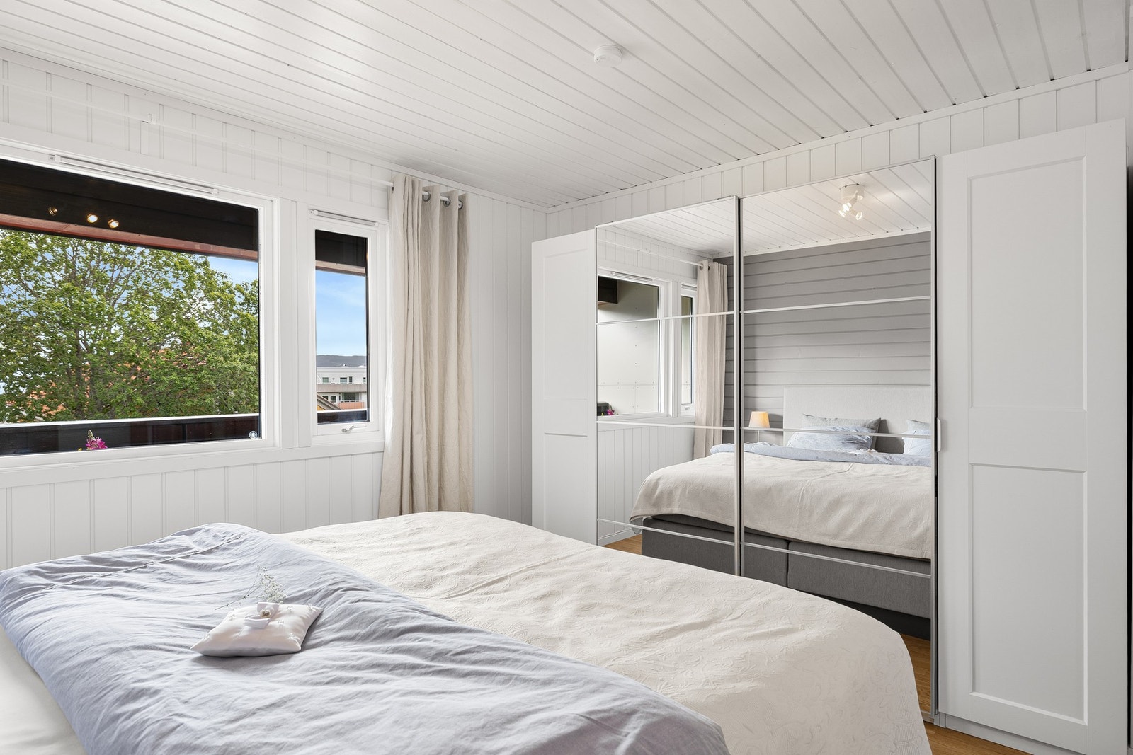Rommet er innredet med en skyvedørsgarderobe med speilfronter som gir rikelig med oppbevaringsplass. Galleribilde